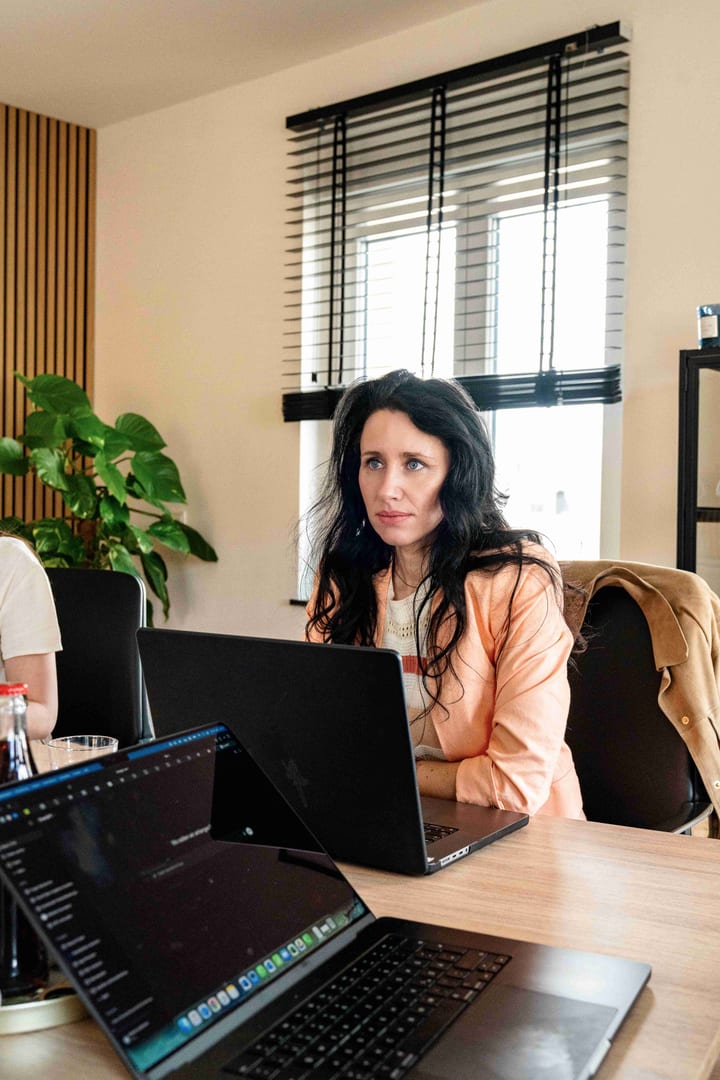 MediaOne Mitarbeiterin arbeitet fokussiert am Laptop während eines Meetings