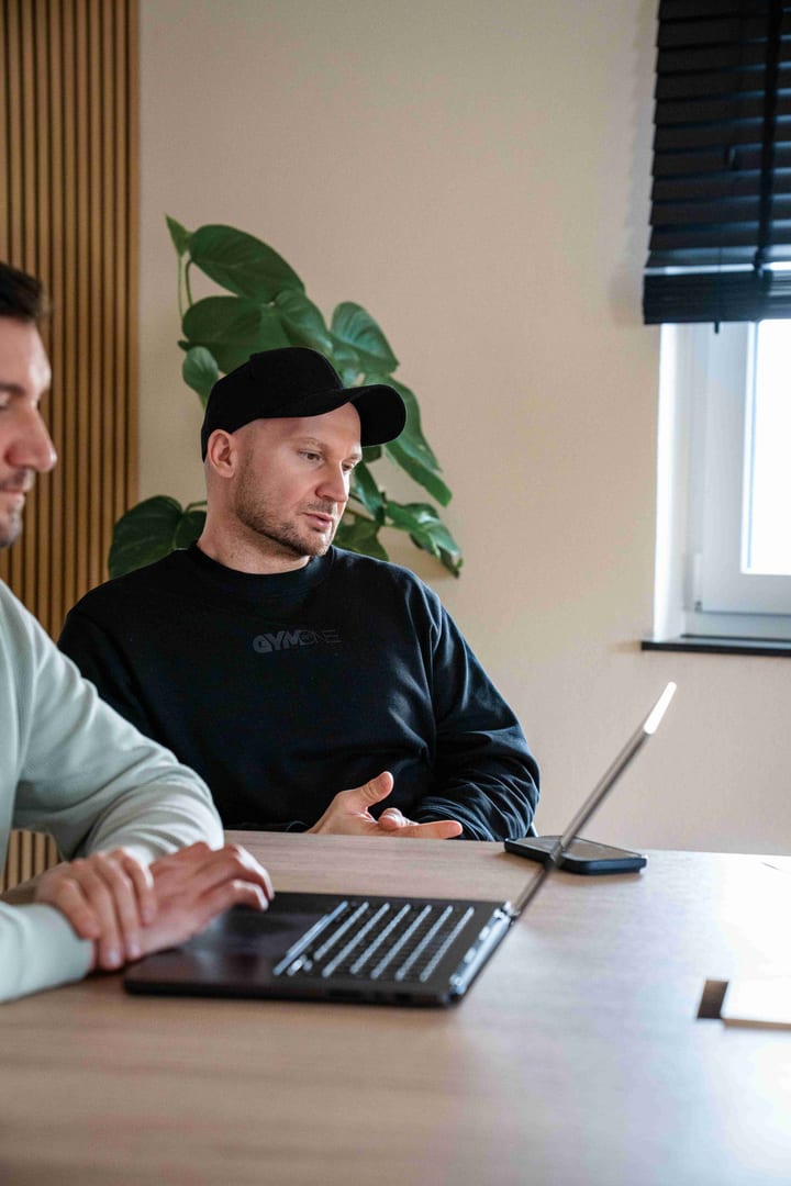 Zwei MediaOne Kollegen besprechen konzentriert eine Kampagne am Laptop